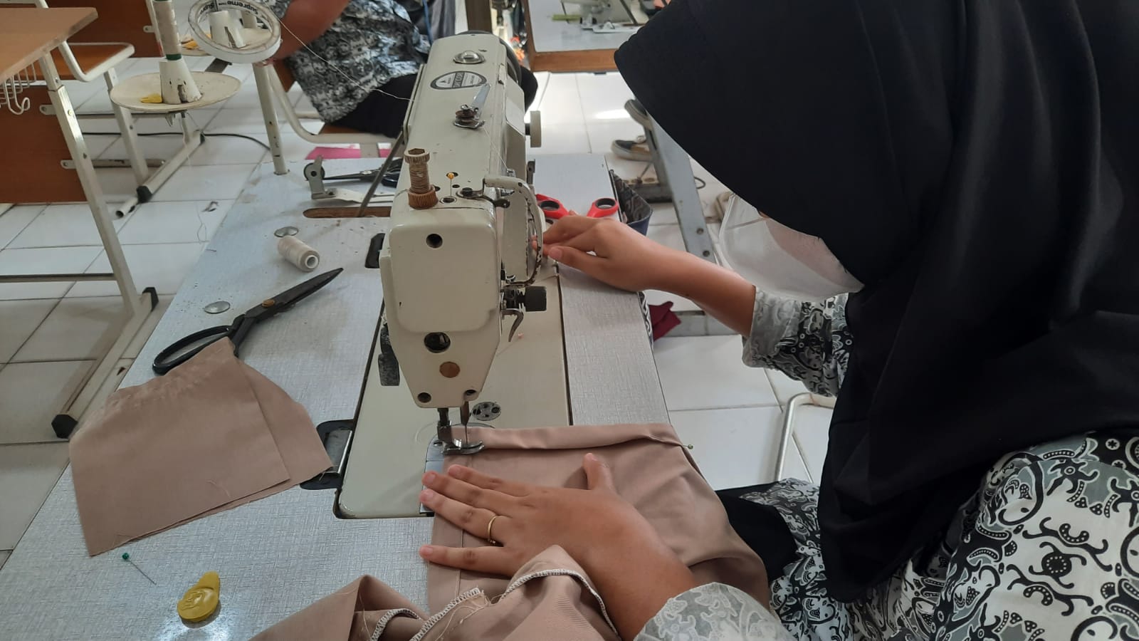 Siswa sedang menjahit pakaian di Life Skill Tata Busana