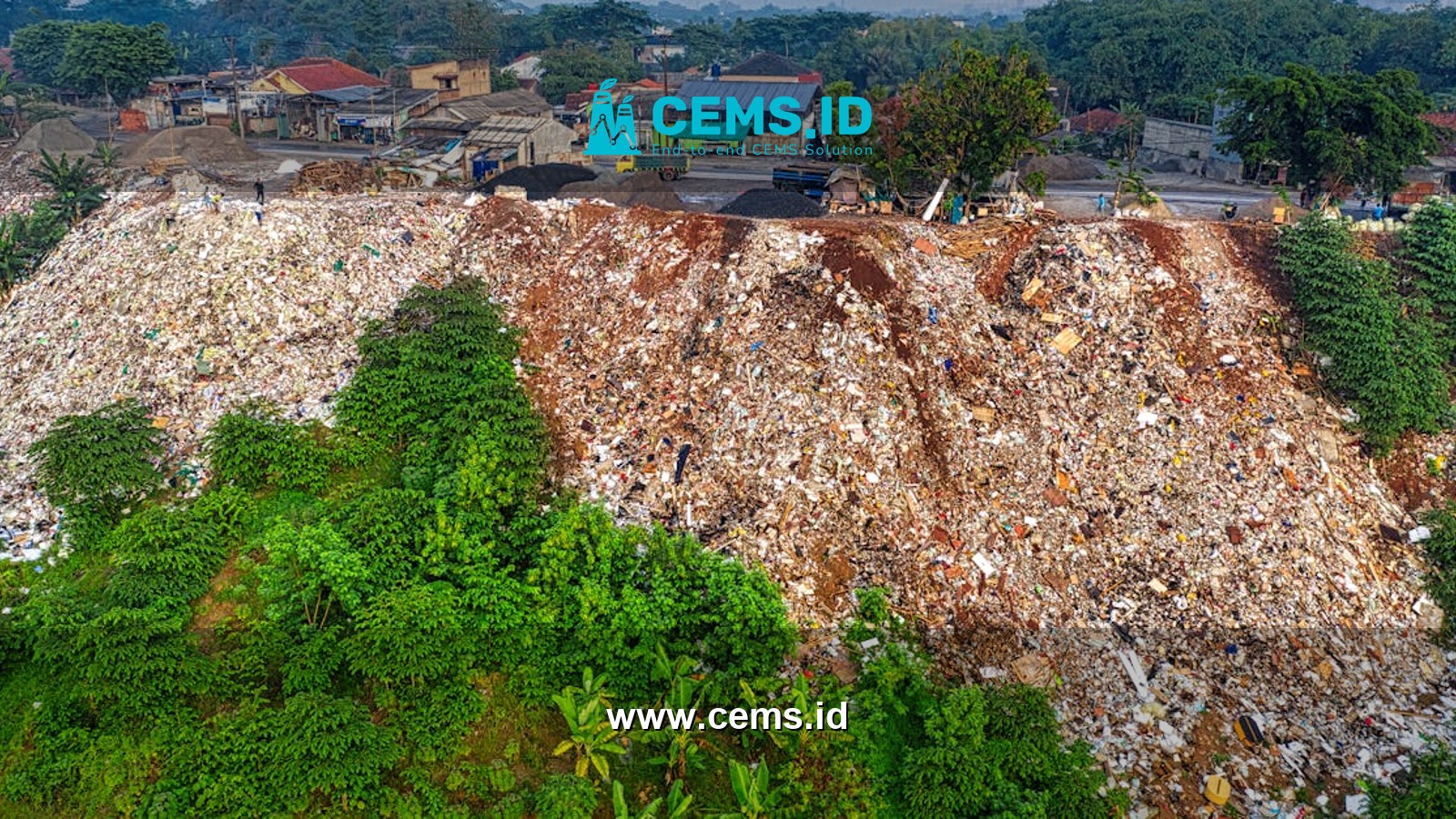 From above of slope of hill covered with rubbish and green plants placed near residential district of tropical city in daylight