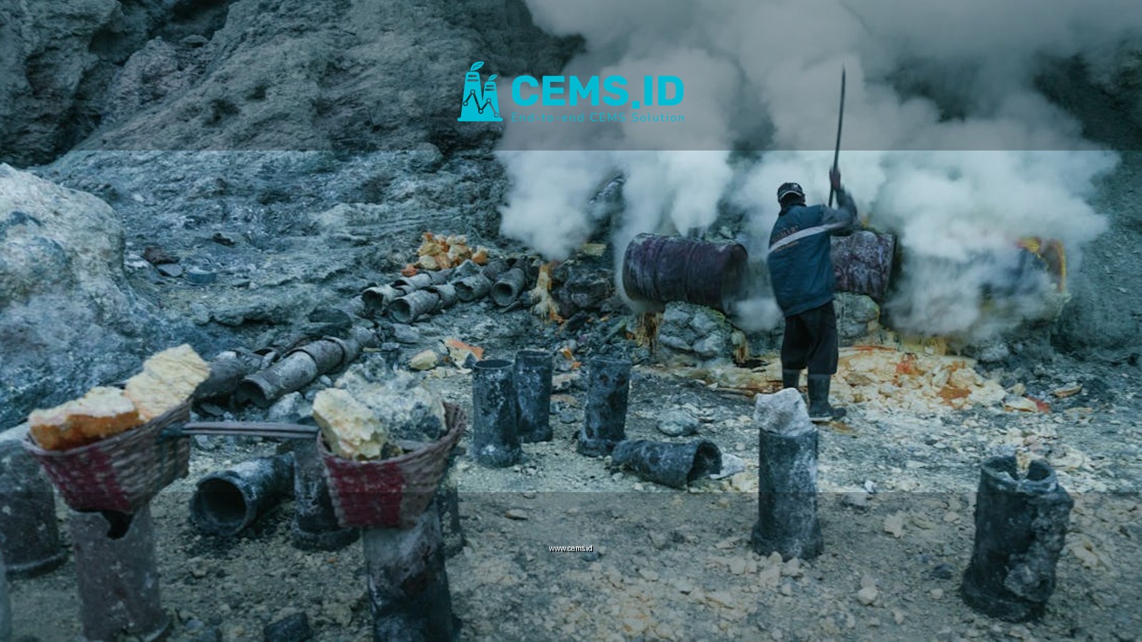 A sulfur miner working amid smoke in a rocky volcanic terrain.