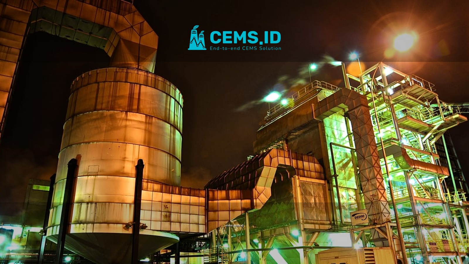 A glowing industrial structure illuminated at night, showcasing complex machinery.