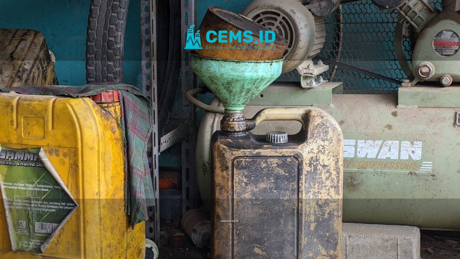 A worn metal drum and vintage compressor in an industrial workshop setting, exuding a classic and rustic feel.
