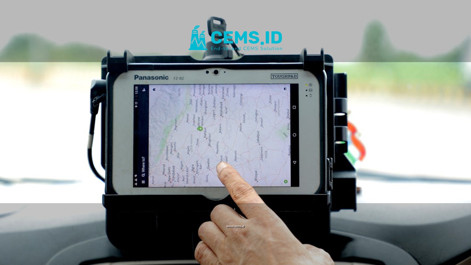Close-up of hand interacting with GPS navigation on a car-mounted tablet screen, showcasing modern technology.