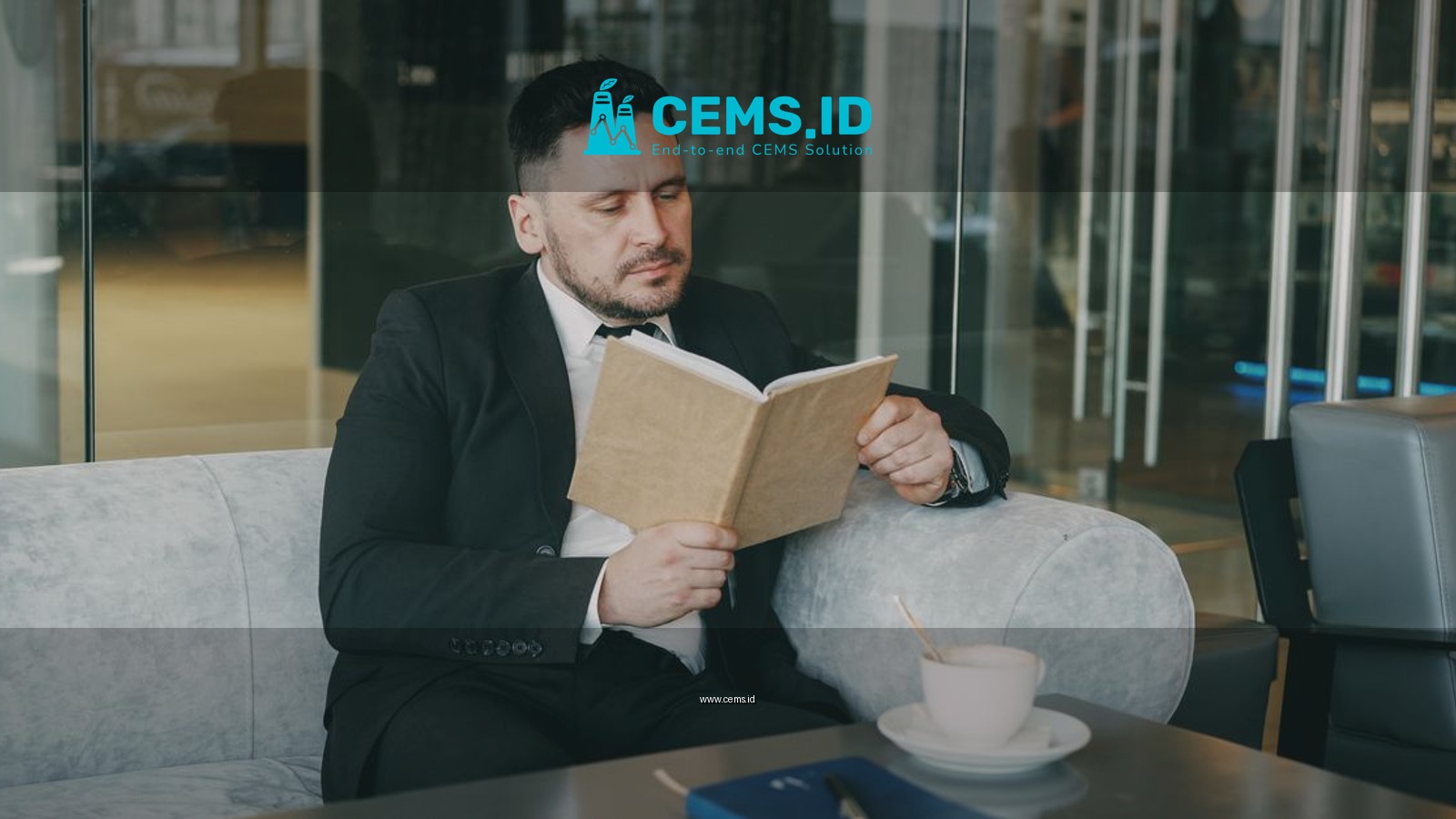 A businessman enjoying a quiet moment reading a book in a contemporary cafe setting.