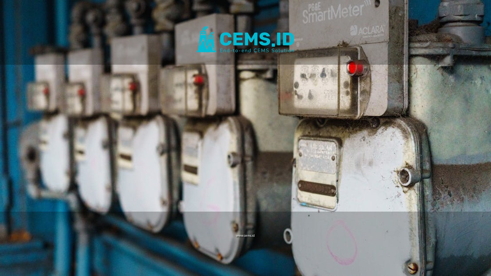 Multiple smart utility meters lined up on a blue industrial wall.
