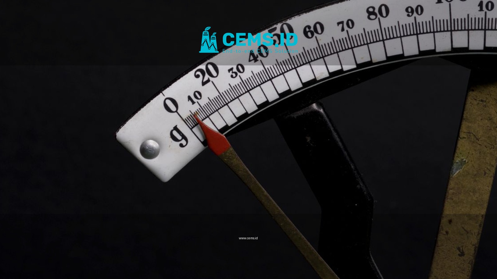 Detailed close-up image of a vintage analog weighing scale with a pointer against a black background.
