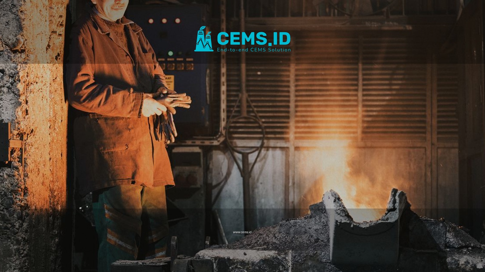 A seasoned worker stands by a furnace in an industrial foundry, casting a warm glow.