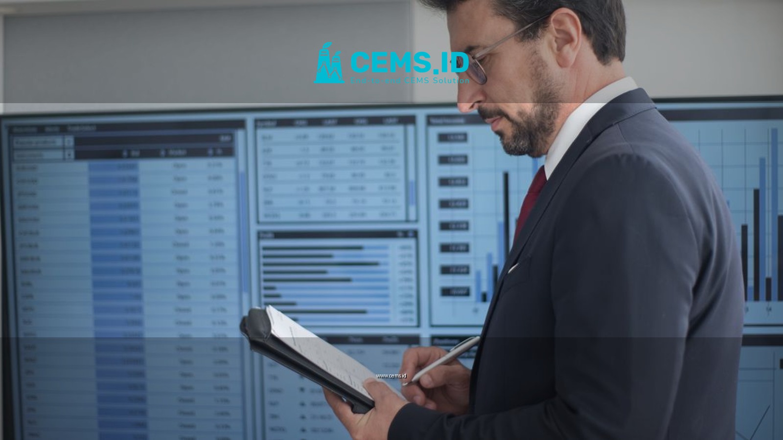Businessman in a suit analyzing data analytics on large screens, taking notes.