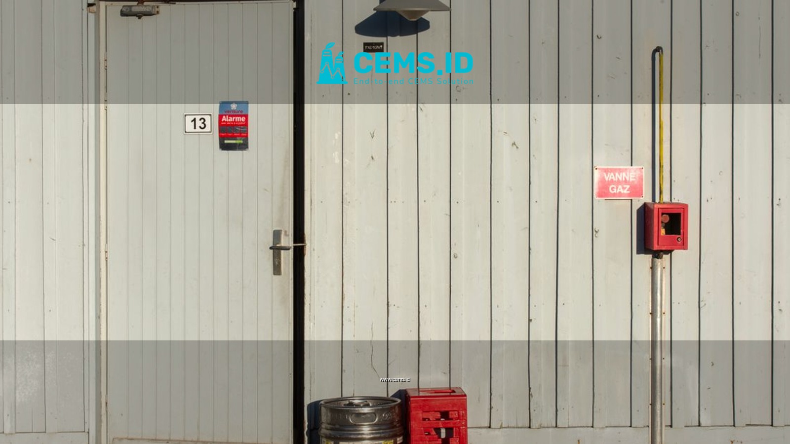 Exterior view of an industrial door with a gas valve and safety signs.