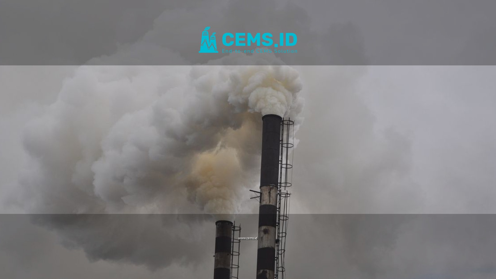 Two smokestacks releasing dense smoke into the overcast sky, highlighting industrial pollution.