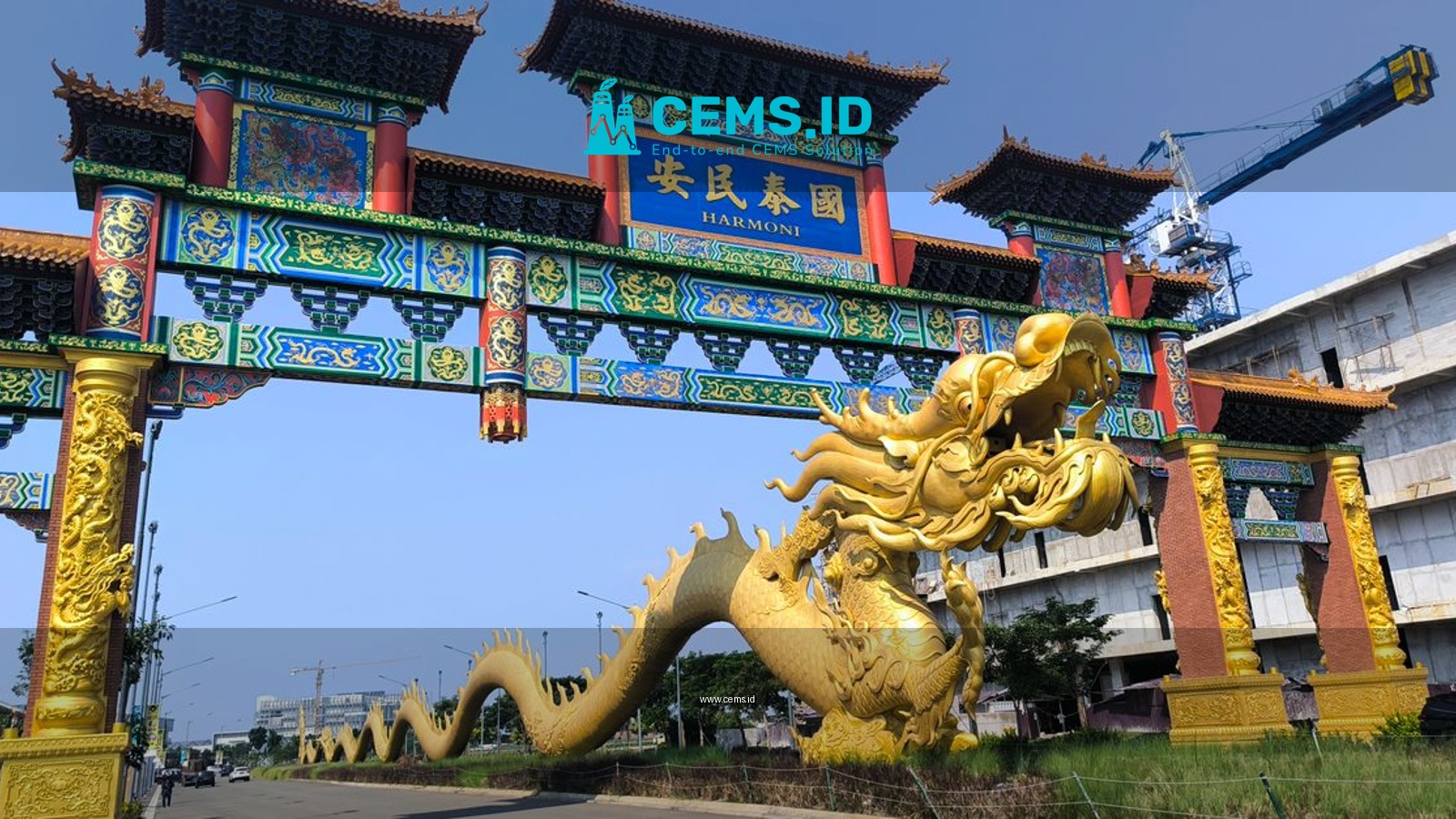A vibrant Chinese archway with a golden dragon sculpture under a clear blue sky.