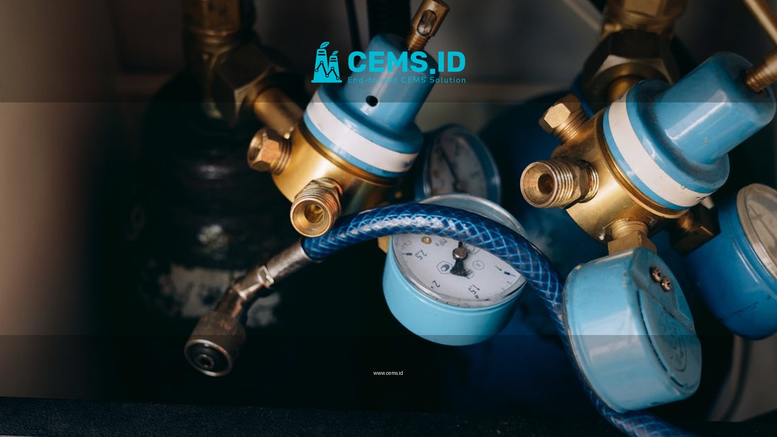 Detailed view of blue and brass gas pressure regulators with gauges and tubing in an industrial setting.