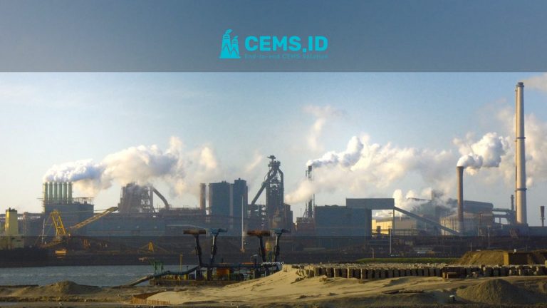 View of the steel plant in IJmuiden, Netherlands with smoke pollution against a clear sky.