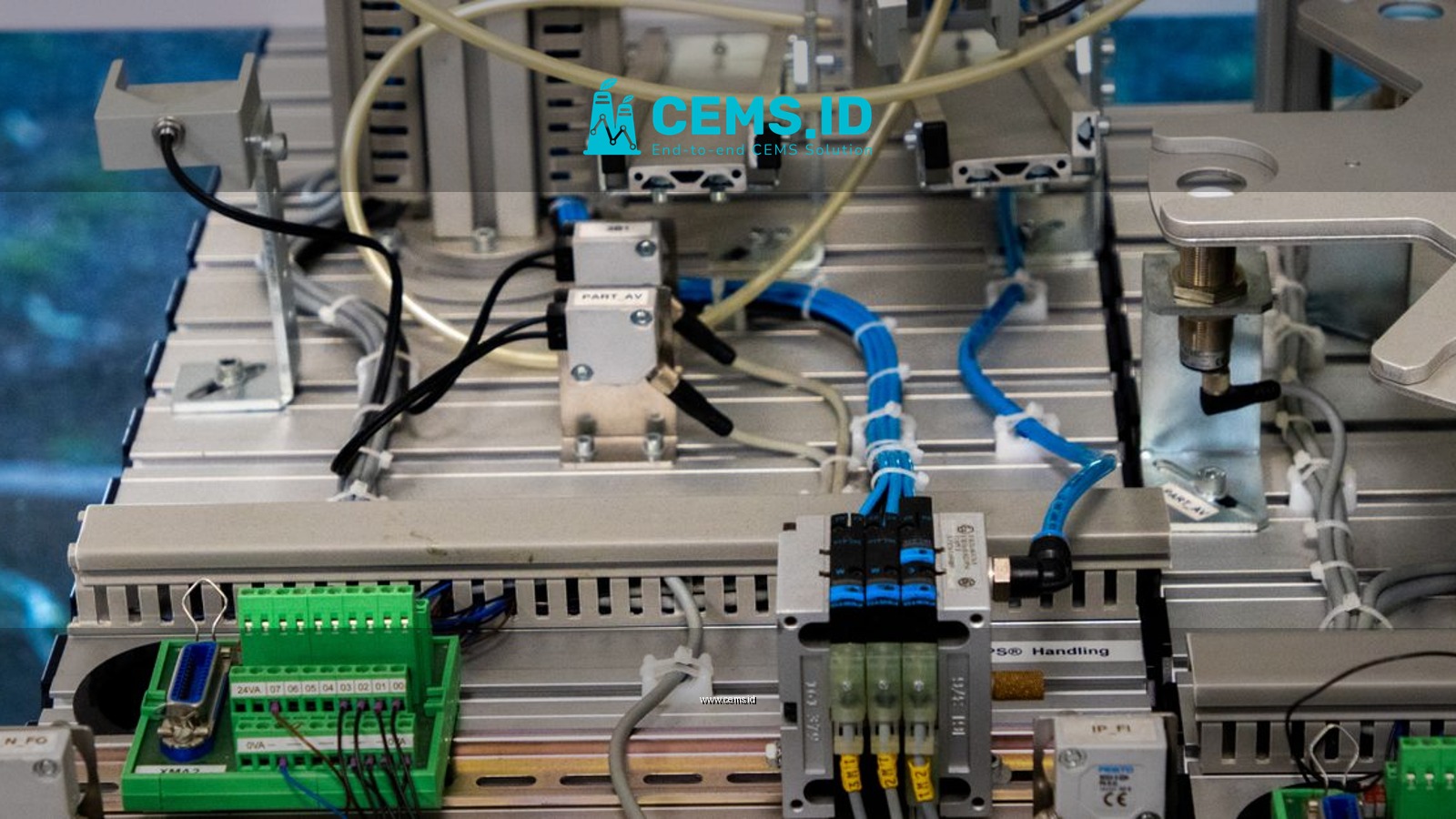 Close-up of industrial equipment showcasing electronic wiring and sensors in a manufacturing setup.