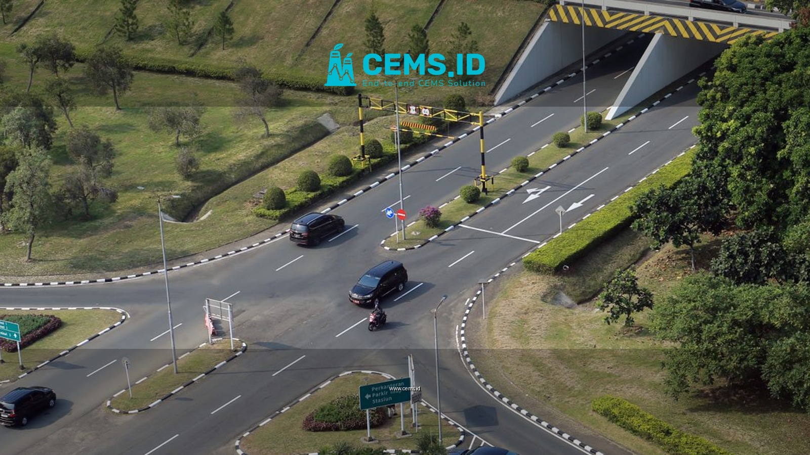 Aerial photo showcasing a busy intersection with cars and greenery, highlighting urban infrastructure and transportation.