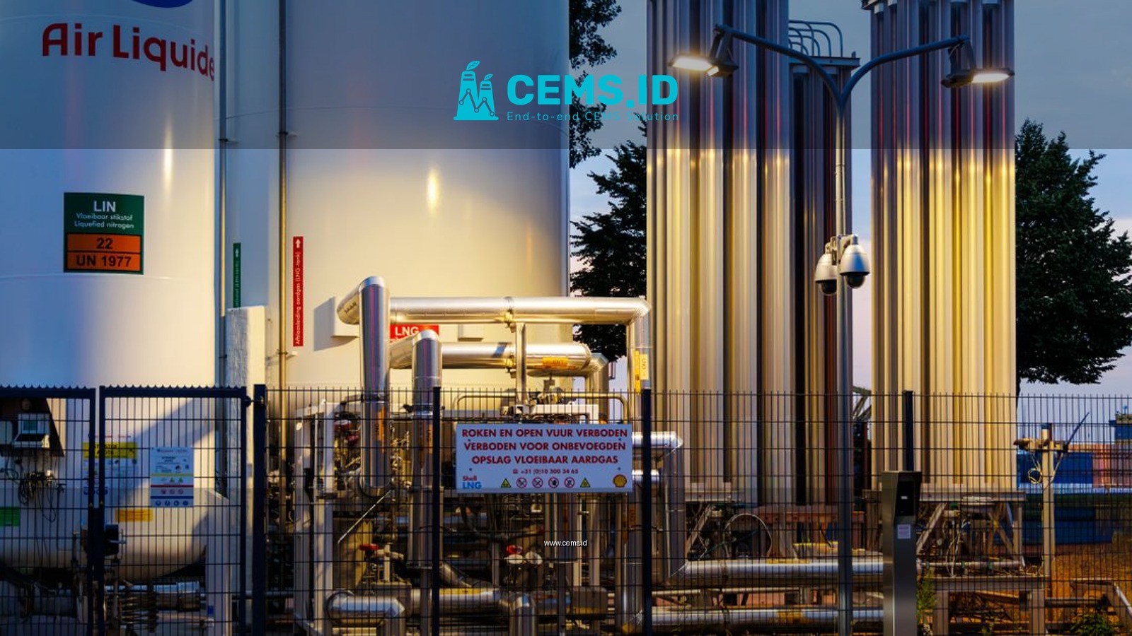Illuminated industrial gas facility in Rotterdam, showcasing equipment and tanks against a twilight backdrop.