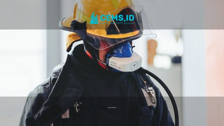 Firefighter wearing full protective gear with helmet and mask indoors.
