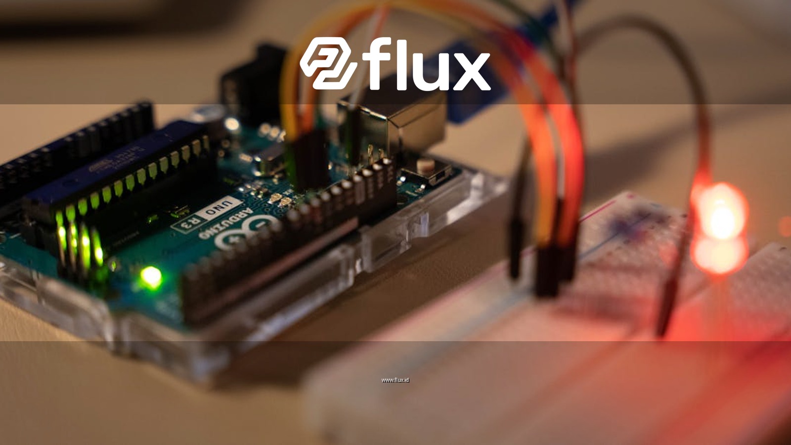 Close-up of Arduino microcontroller connected to a breadboard with a glowing LED.