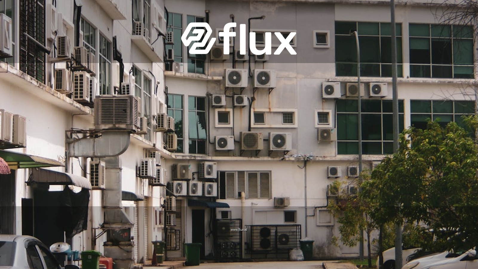 Exterior view of a building with multiple air conditioners and parked cars