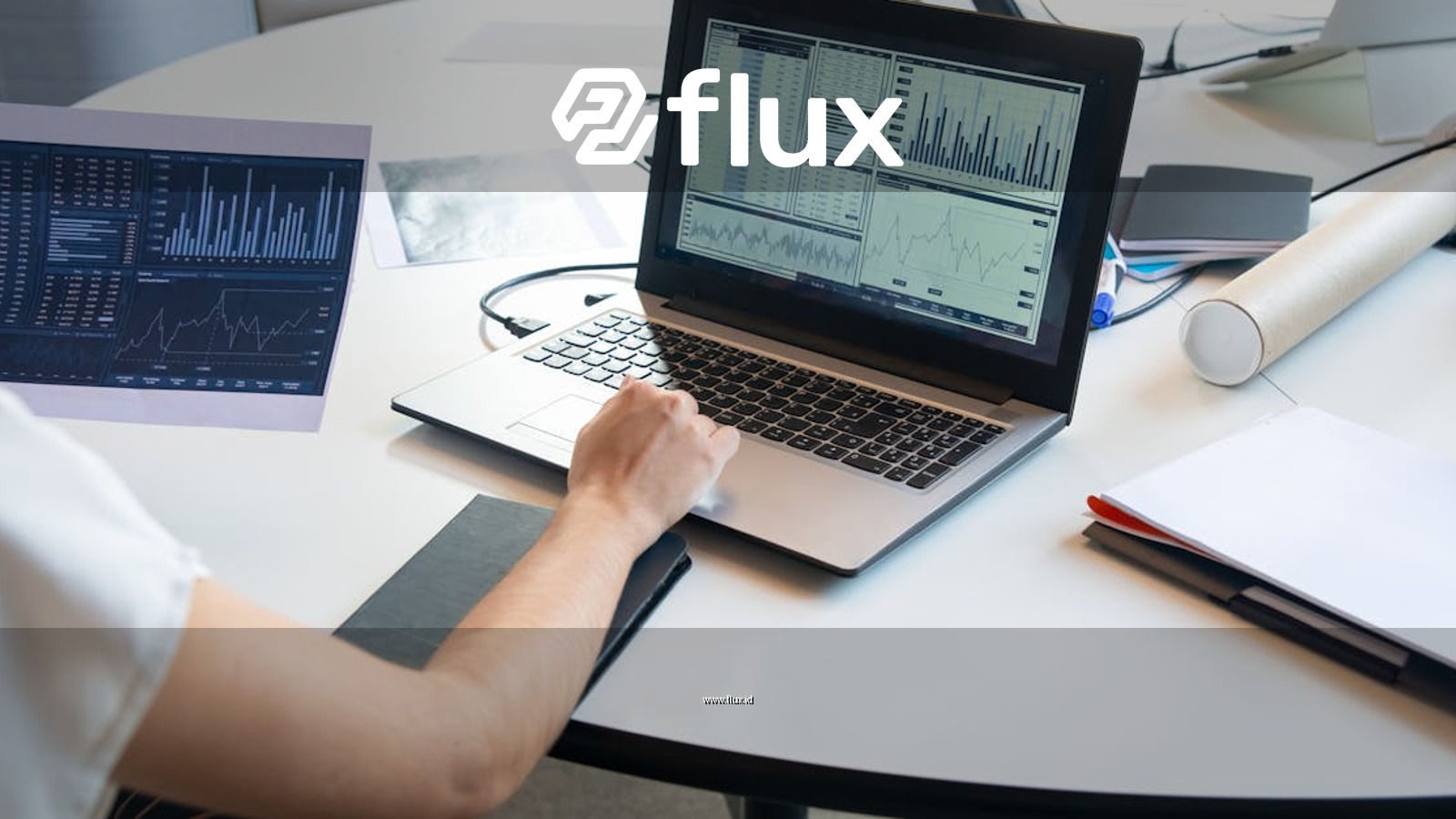 Business person evaluating financial charts on a laptop in a modern office setting.