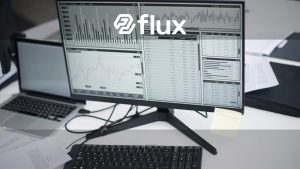 A professional workspace featuring computers and analytical graphs on a monitor, symbolizing modern business environment.