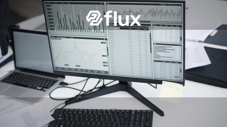 A professional workspace featuring computers and analytical graphs on a monitor, symbolizing modern business environment.