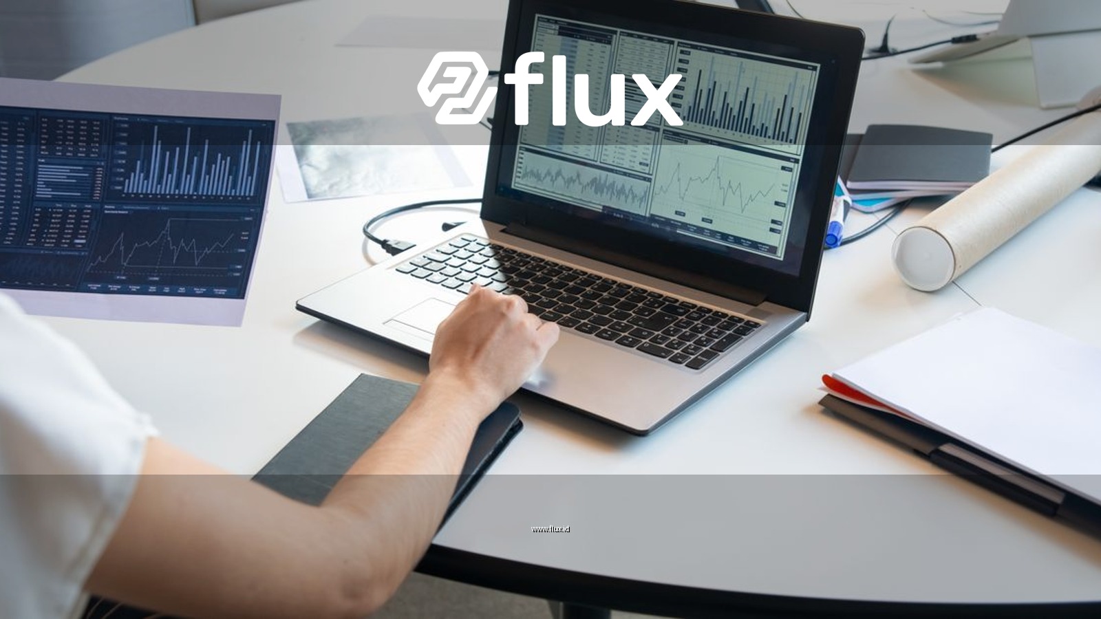 Business person evaluating financial charts on a laptop in a modern office setting.