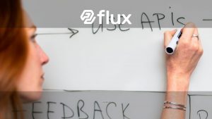 A woman writes 'Use APIs' on a whiteboard, focusing on software planning and strategy.