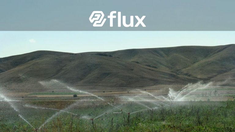 A vibrant sprinkler irrigation system in action across lush cropland and rolling hills.