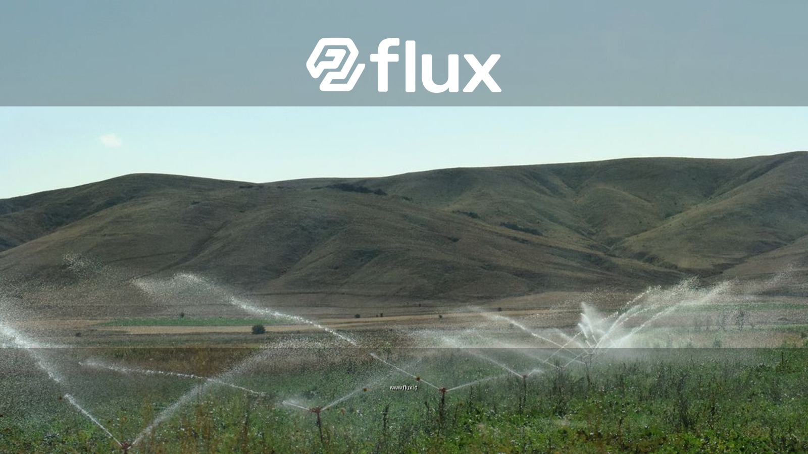 A vibrant sprinkler irrigation system in action across lush cropland and rolling hills.