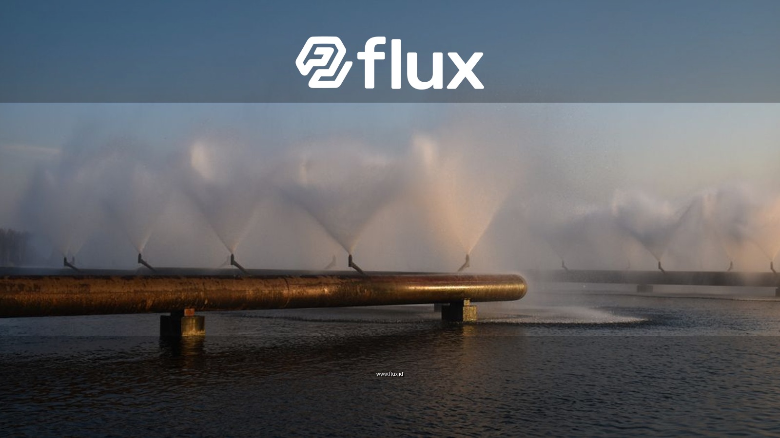 A scenic view of industrial water pipes creating fountain effects over a calm water surface at sunset.