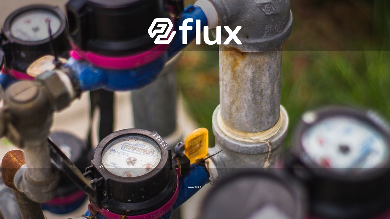 Detailed image of industrial water pressure gauges and pipes in an outdoor setting.