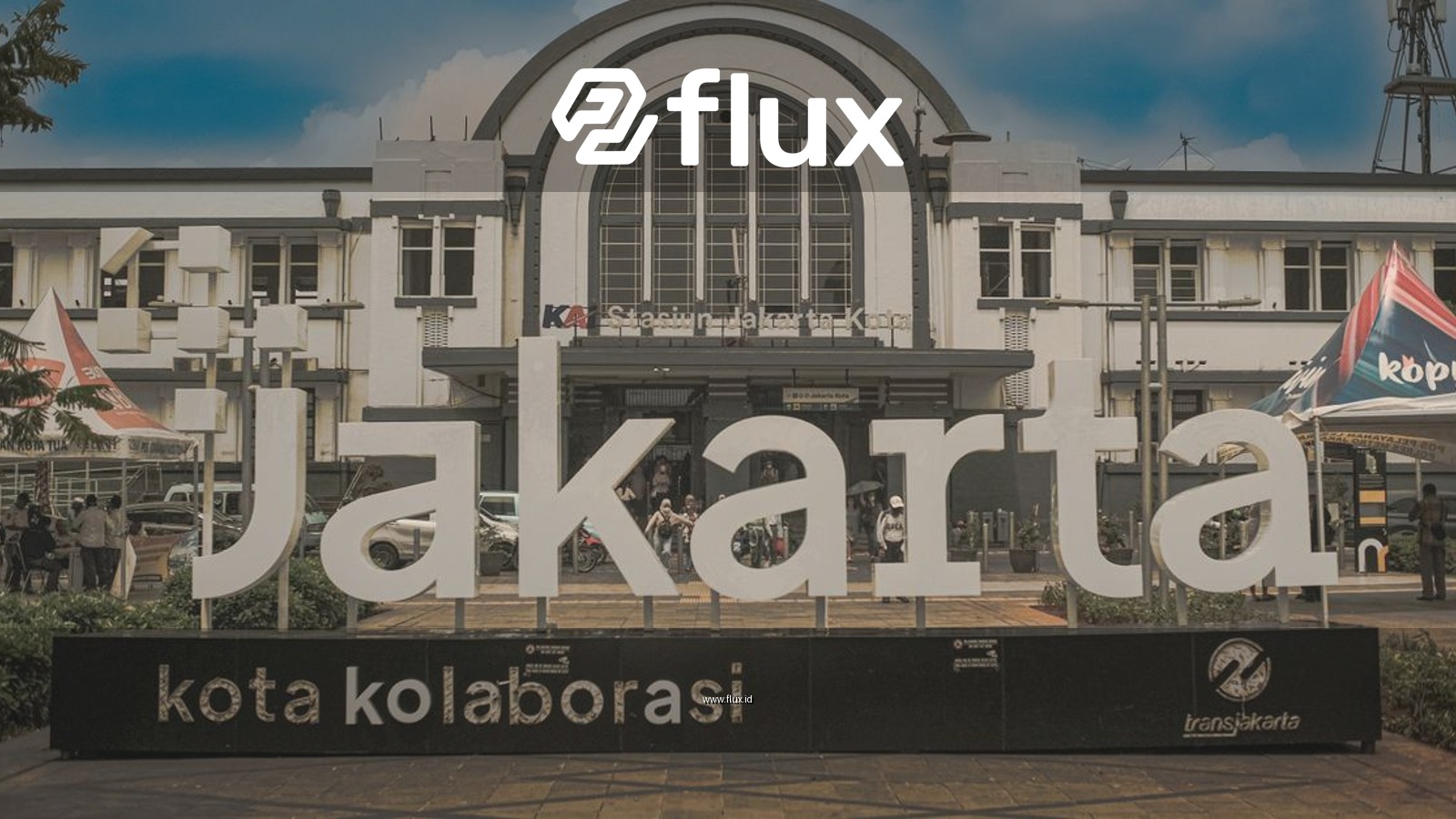 Front view of Jakarta's iconic train station featuring modern 'Jakarta' sign, showcasing urban mix.