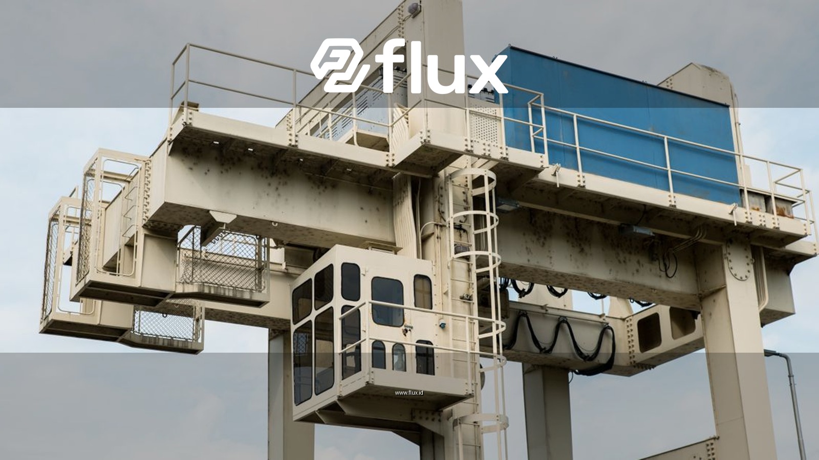 Close-up view of a large industrial crane against a blue sky, showcasing metal structure details.