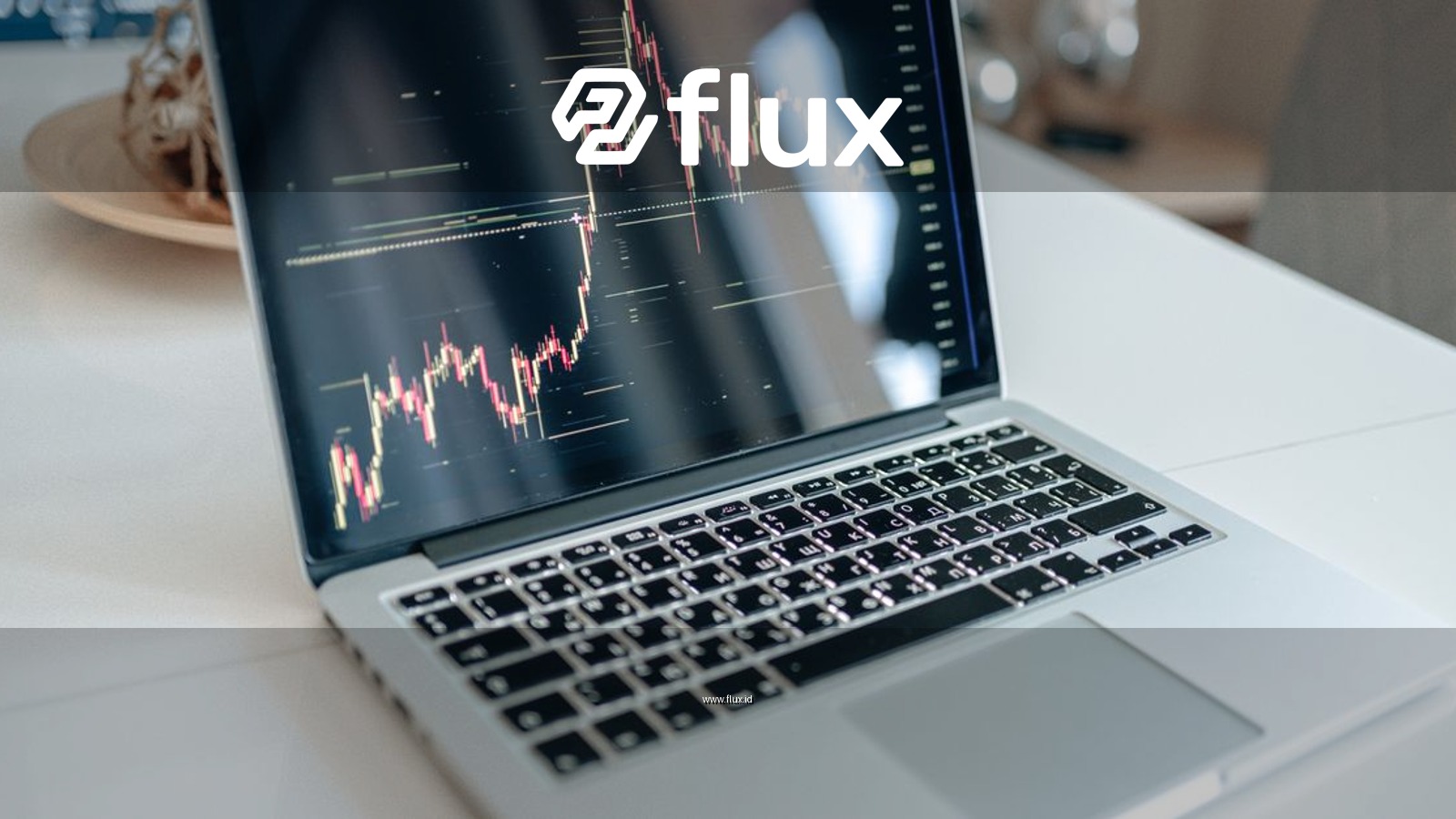 Laptop showing cryptocurrency market data on a white table, indoors.