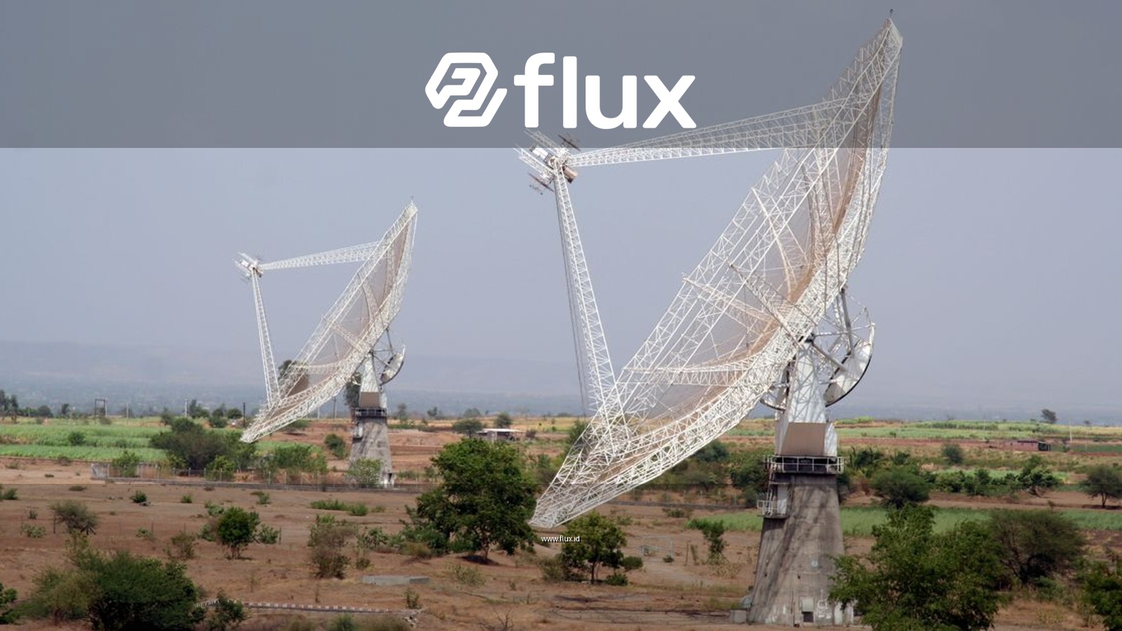 Two large satellite dishes in a rural field near Pune, India, capturing signals.