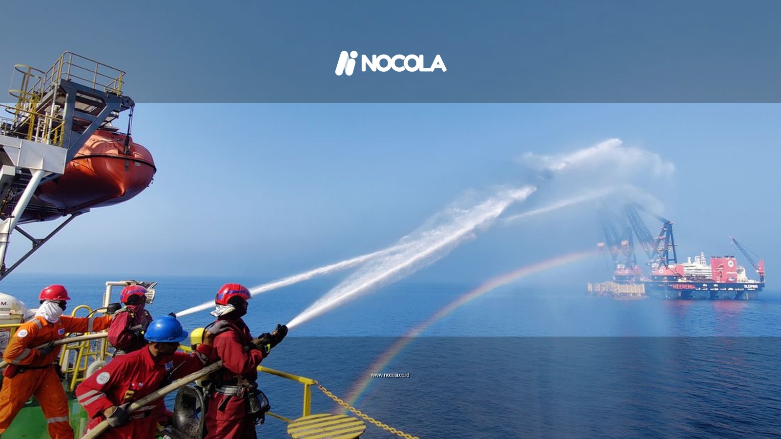 Workers on an offshore platform demonstrate teamwork using water hoses under a clear sky.
