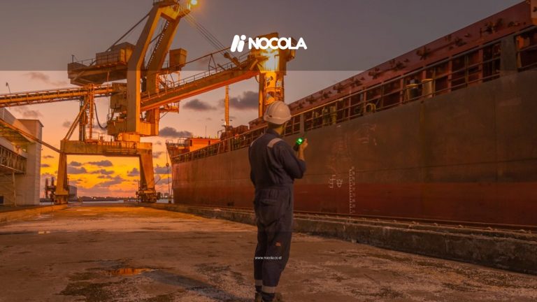 A dock worker examines a cargo ship under twilight skies at a Libyan port, highlighting industrial operations.