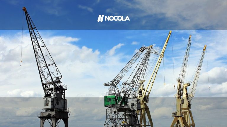 Industrial cranes reaching into a bright blue sky with scattered clouds, a symbol of construction and industry.