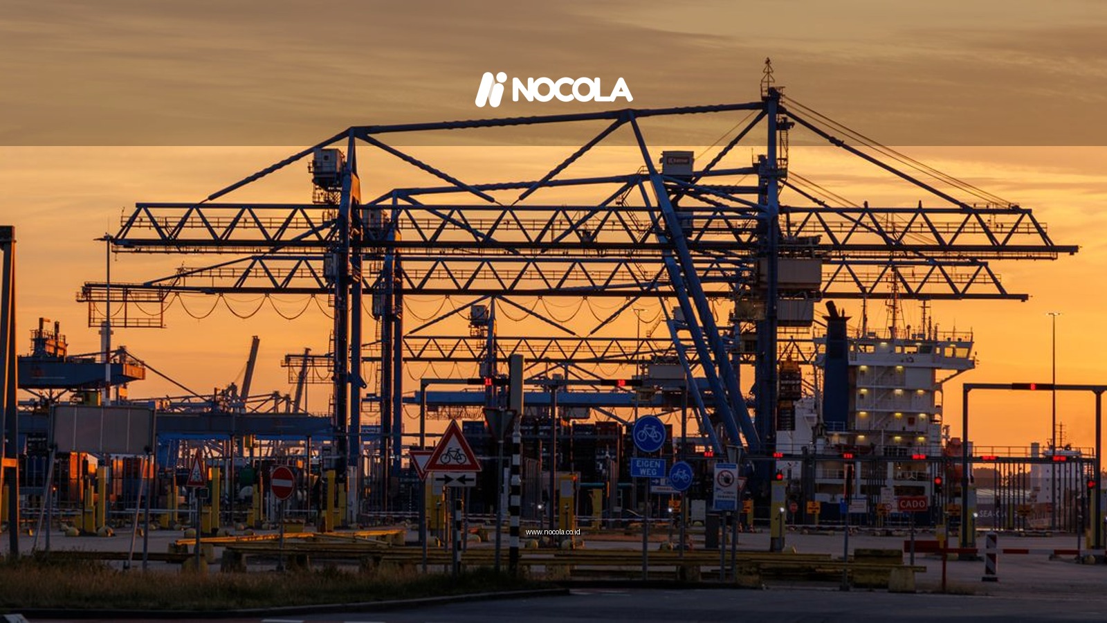 Silhouettes of cranes at Rotterdam port during a vibrant sunset.