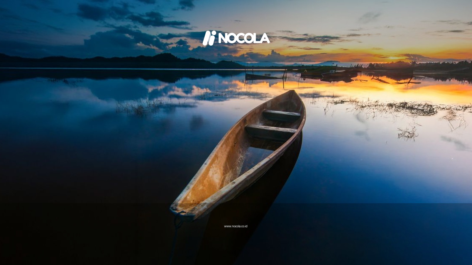 A serene boat on calm waters reflecting a stunning sunset in Rantau Panjang, Malaysia.