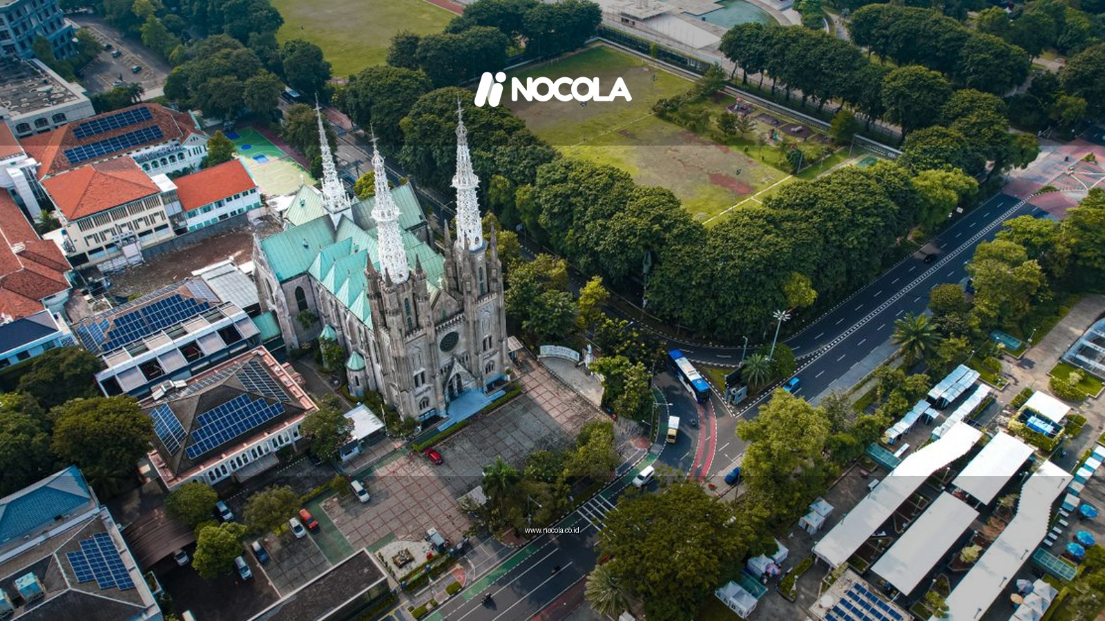 Aerial shot of Jakarta Cathedral showcasing its gothic architecture amidst lush greenery.