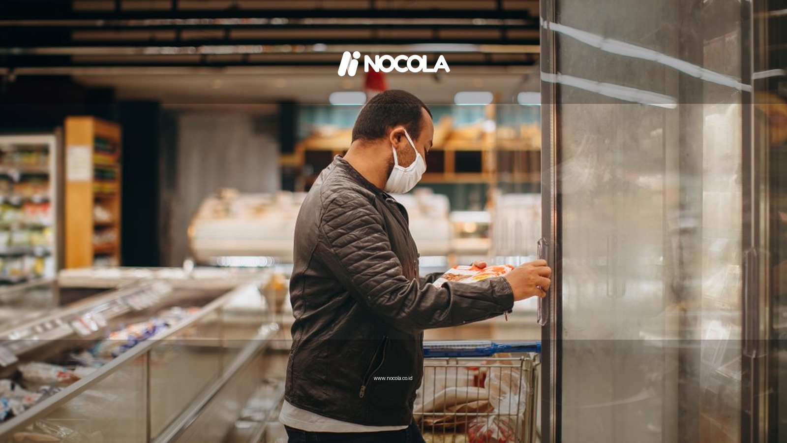 A man wearing a mask shops in a supermarket, selecting items from a refrigerated section.