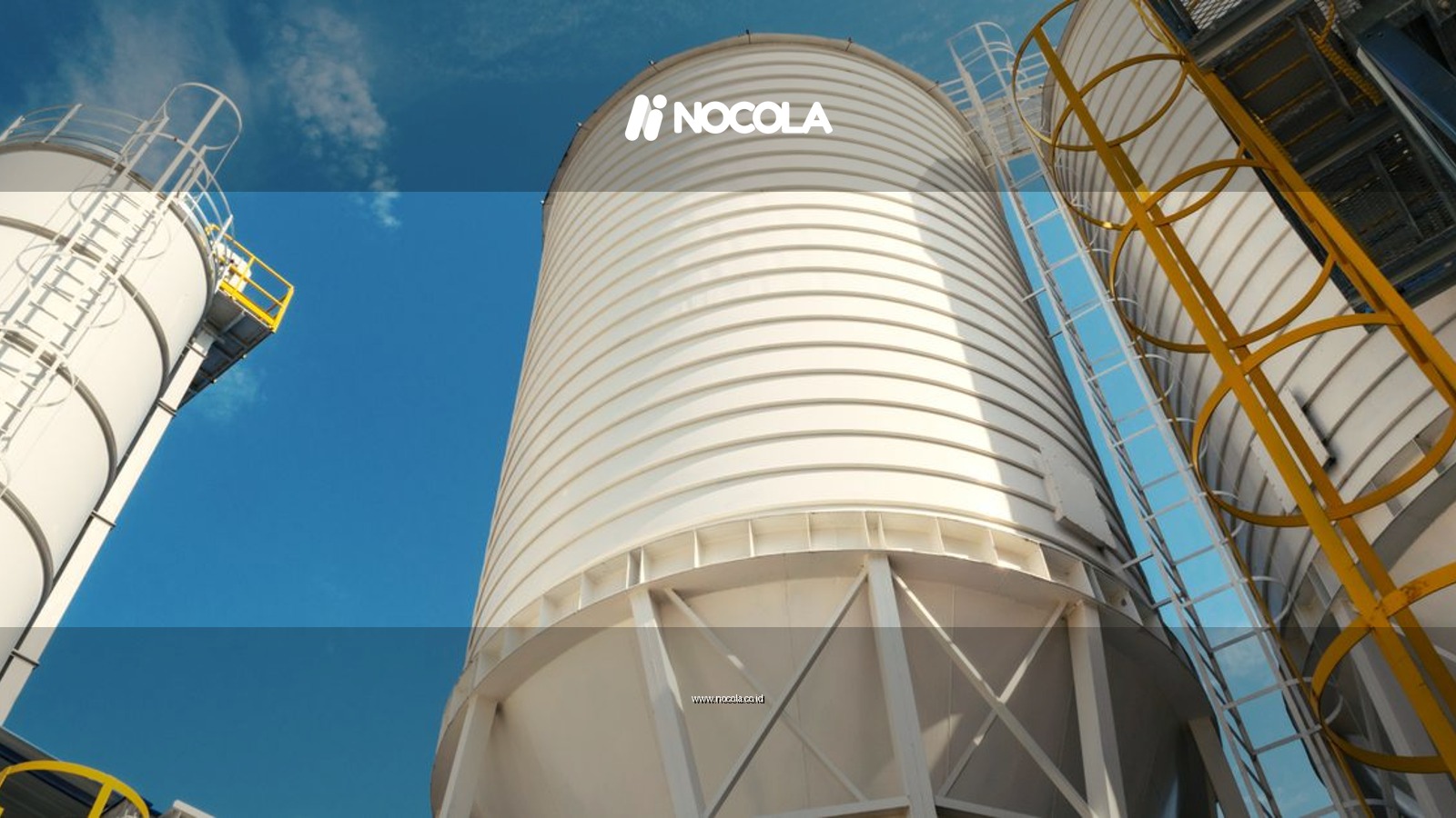 Wide-angle view of industrial silos with clear blue sky, captured during daytime, showcasing modern industry.
