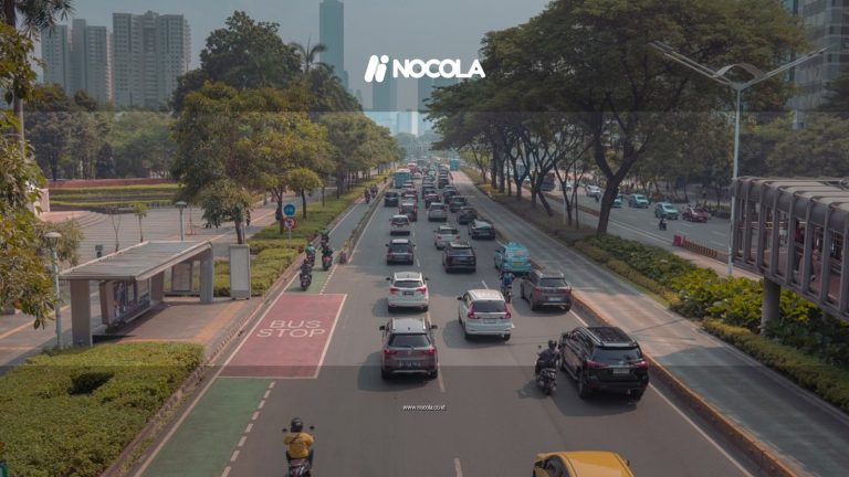 A bustling urban roadway in Jakarta with cars, motorbikes, and a bus stop in view.