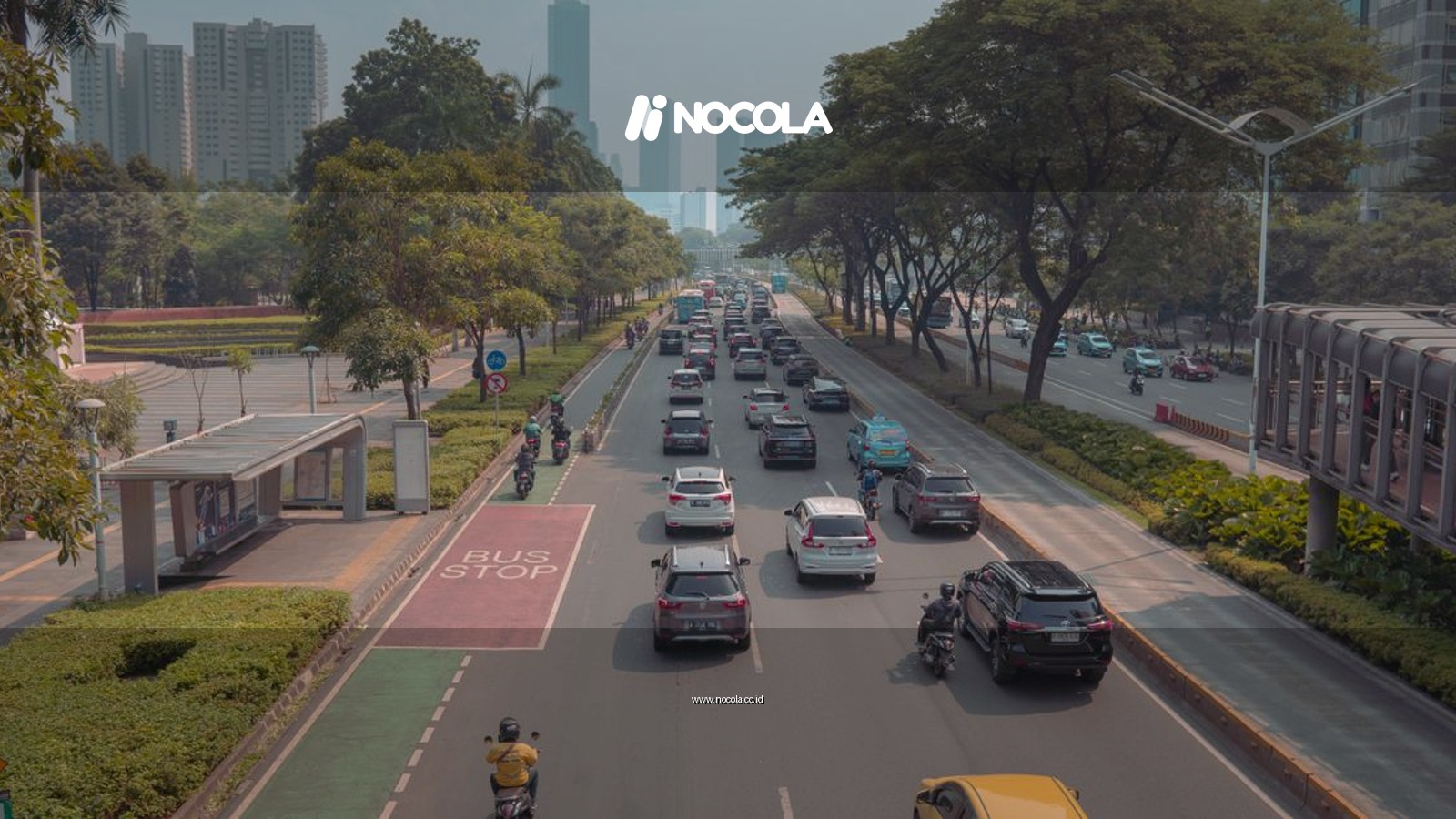 A bustling urban roadway in Jakarta with cars, motorbikes, and a bus stop in view.