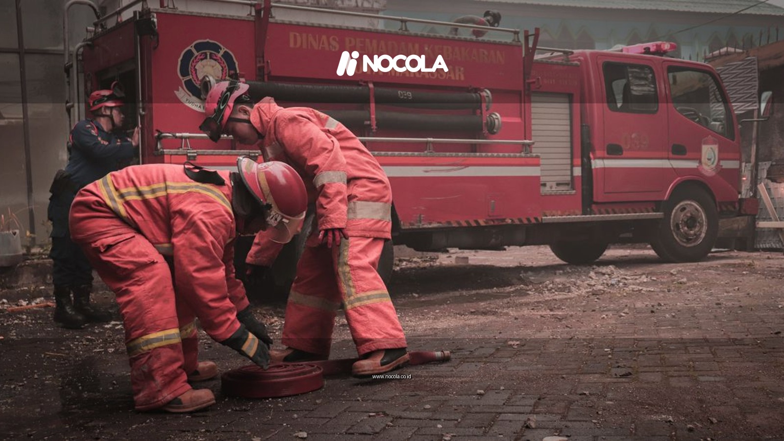 Firefighters working diligently during a street emergency in Makassar, Indonesia, showcasing teamwork and bravery.