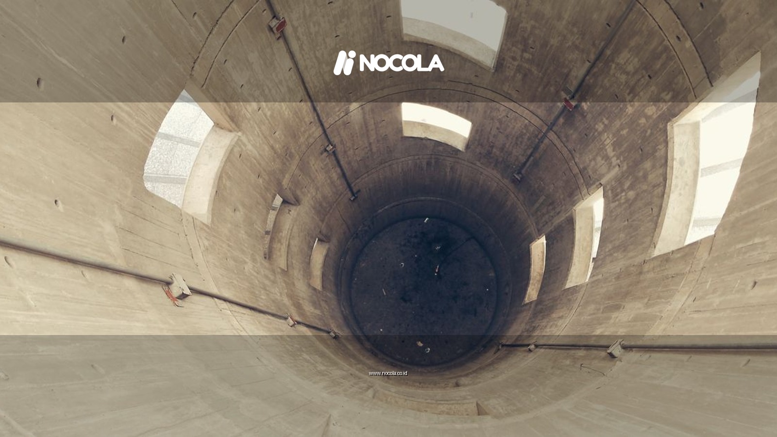 A downward perspective inside a massive concrete silo with geometric windows.