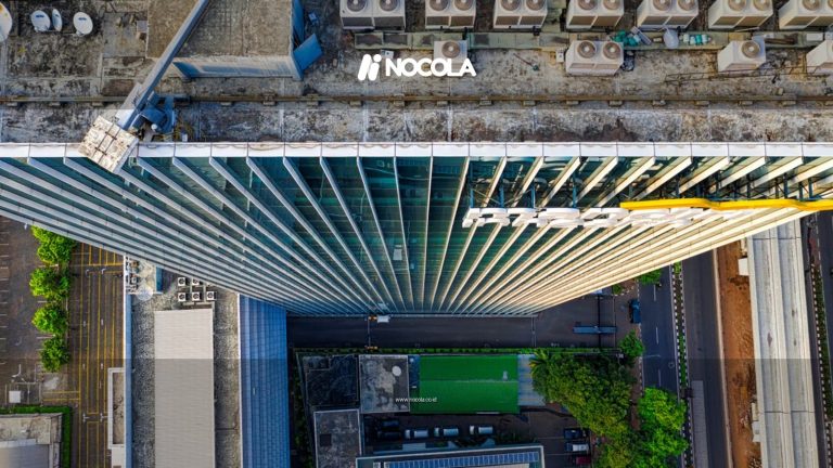 Aerial perspective of a skyscraper rooftop with urban surroundings, showcasing city architecture.