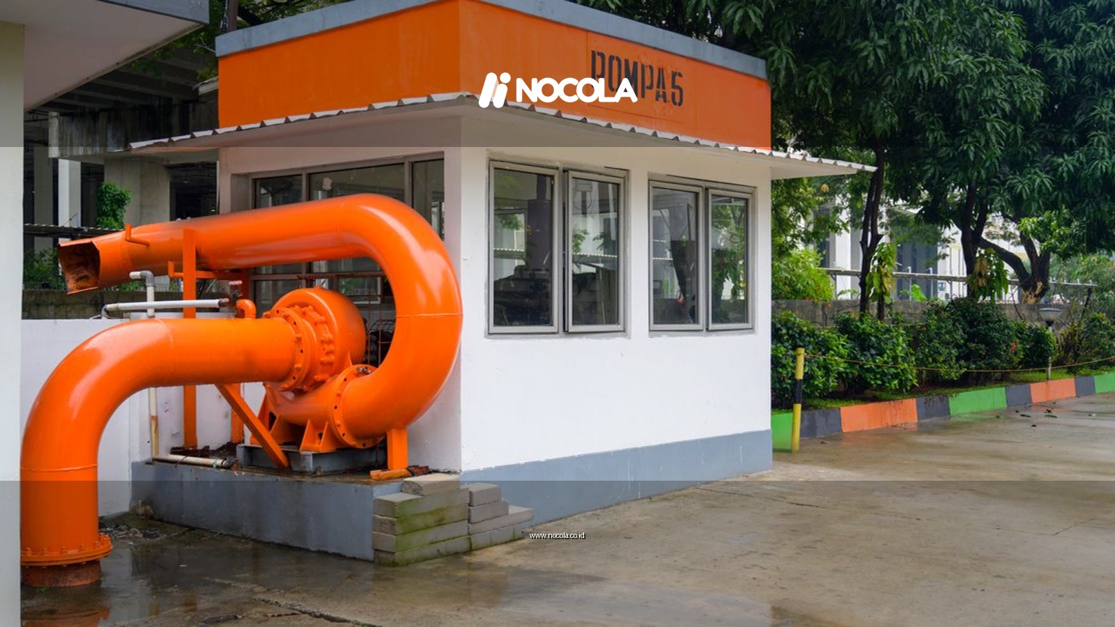 Bright orange pump station structure in Jakarta with greenery around.