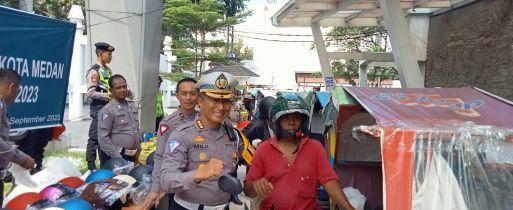 Dirlantas Polda Sumut, Kombes Muji Ediyanto saat membagikan helm SNI dalam rangka Operasi Zebra (int)